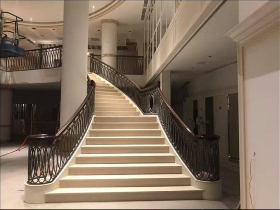 Escalier monumental courbe installé sur un chantier commercial à Laval