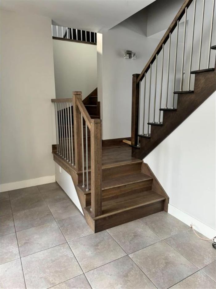 Escalier tournant en bois foncé, modification pour ajout d'étage