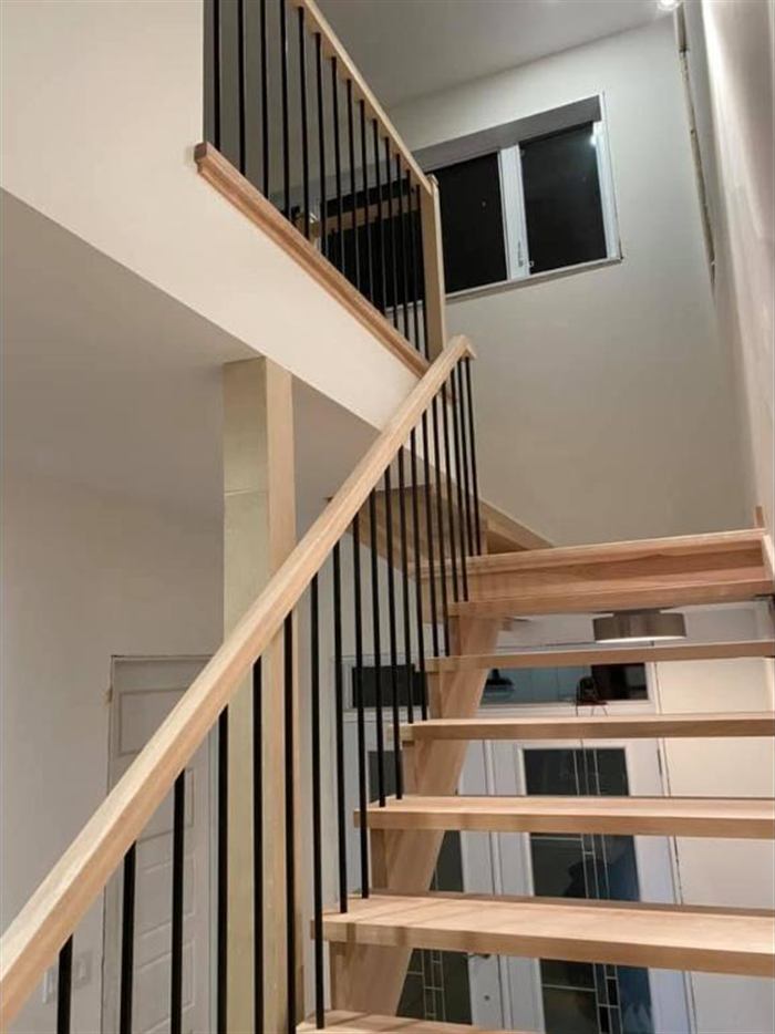 Escalier flottant en merisier avec barreaux noirs