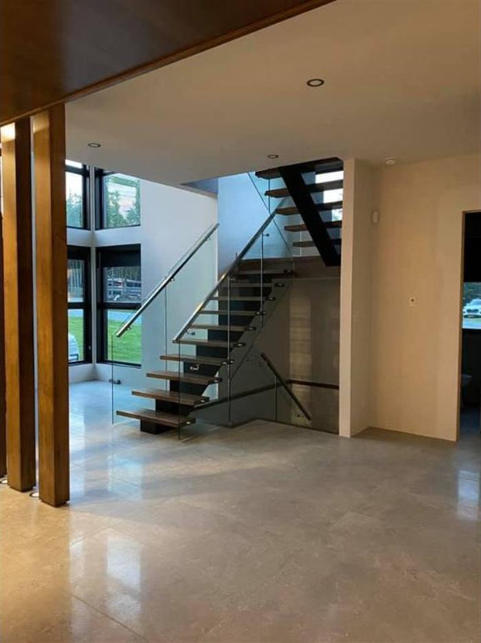Escalier flottant et garde-corps de verre dans une maison d'architecte