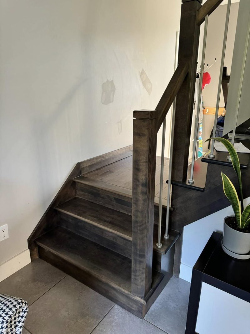 Escalier tournant en bois teint foncé avec poteau et garde-corps