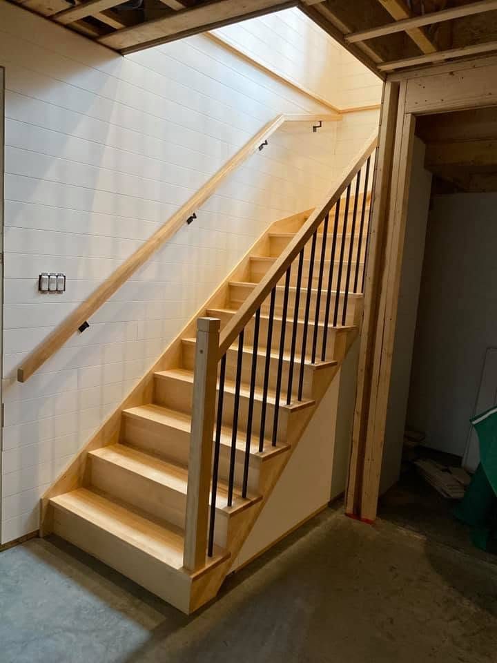 Escalier en bois clair avec main courante murale et barreaux de bois
