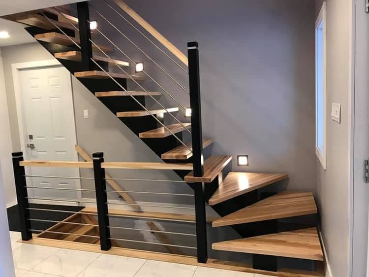 Escalier flottant à limon noir, marches de bois et garde-corps à câbles