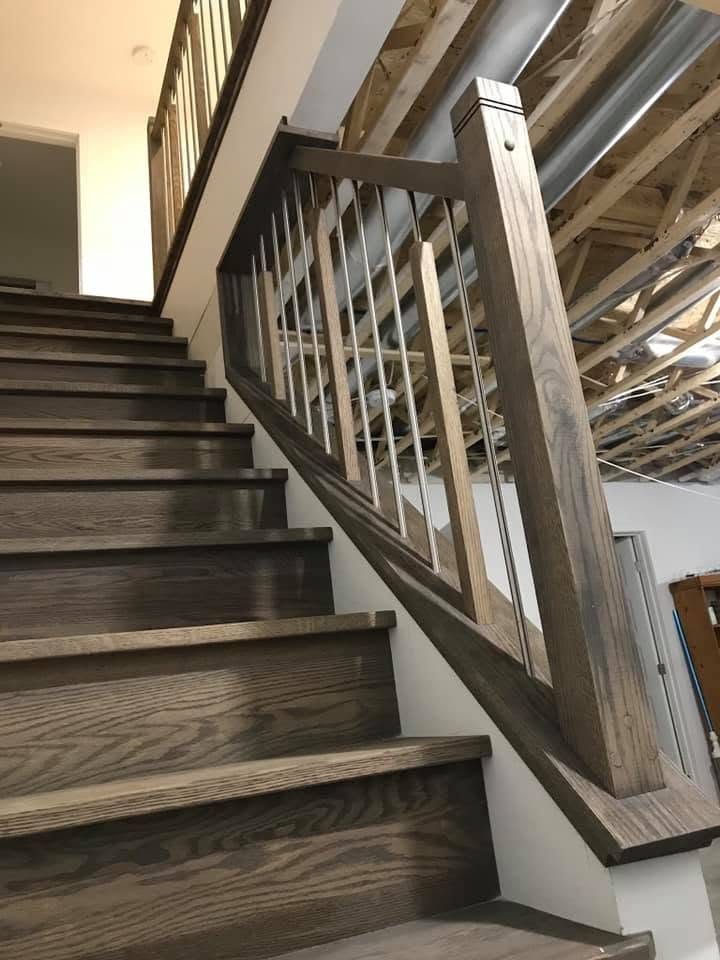 Escalier droit en bois foncé avec garde-corps à barreaux de bois